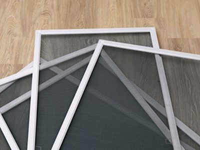 Pleated blinds with orange folded fabric on the window close up.